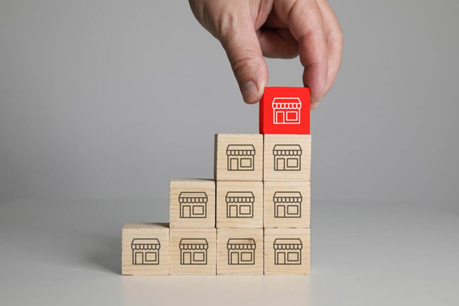 A hand placing a red block on a stack of wooden blocks
AI-generated content may be incorrect.